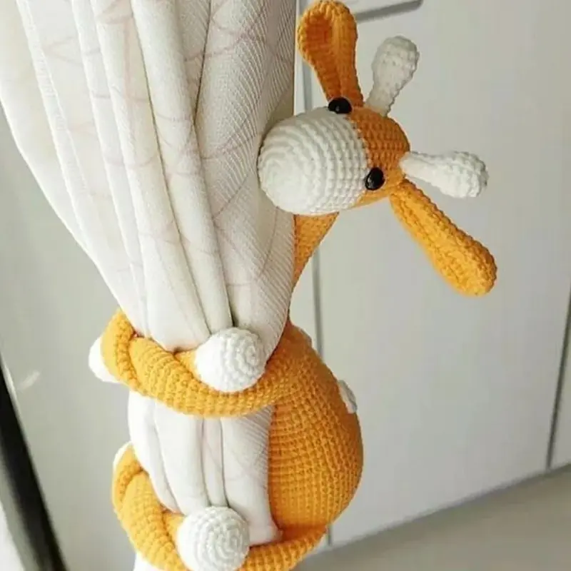 Crochet Giraffe Amigurumi Hugging the Curtains — Free Pattern, the finished crochet build, photographed on a plain surface